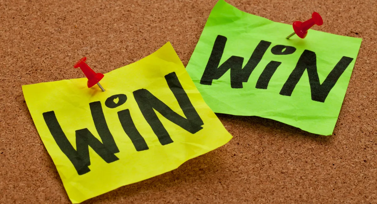 Gehaltserhöhung: zwei Post-its die an einer Pinnwand stecken mit jeweils der Aufschrift "win" drauf, also "win" "win"