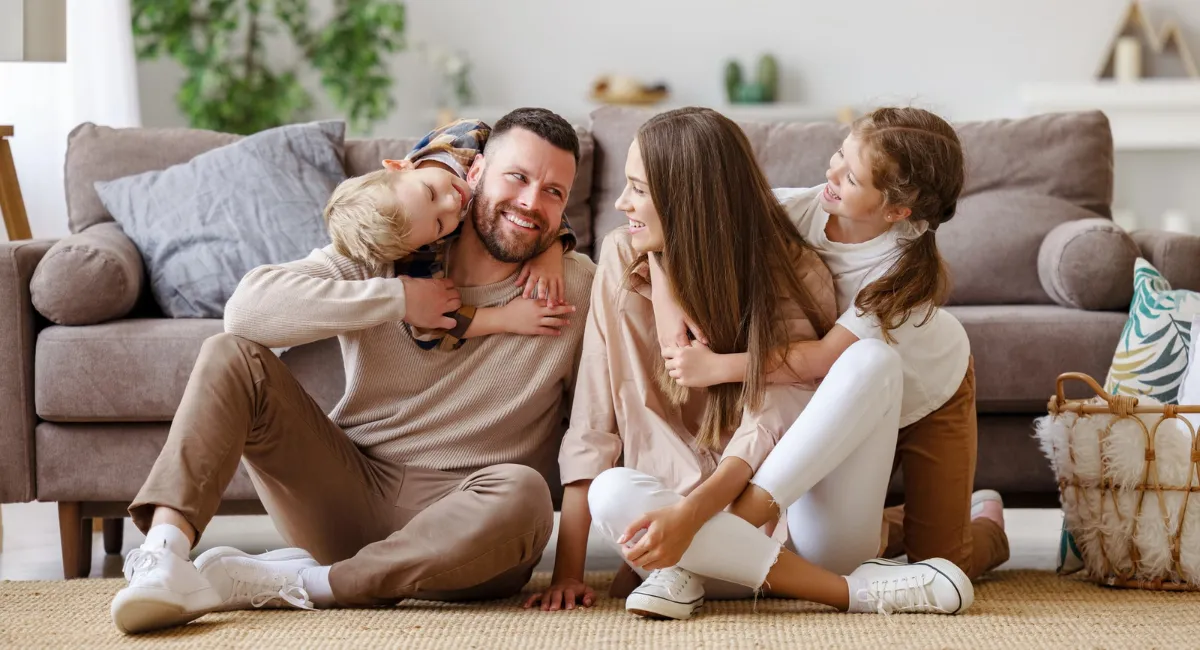 Glückliche Eltern mit zwei Kindern als Zeichen für eine resiliente Familie