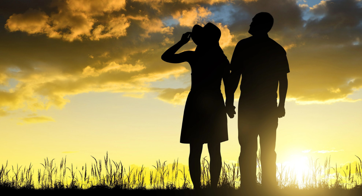 Glückliche Silhoutten eines glücklichen Paares beim Sonnenaufgang